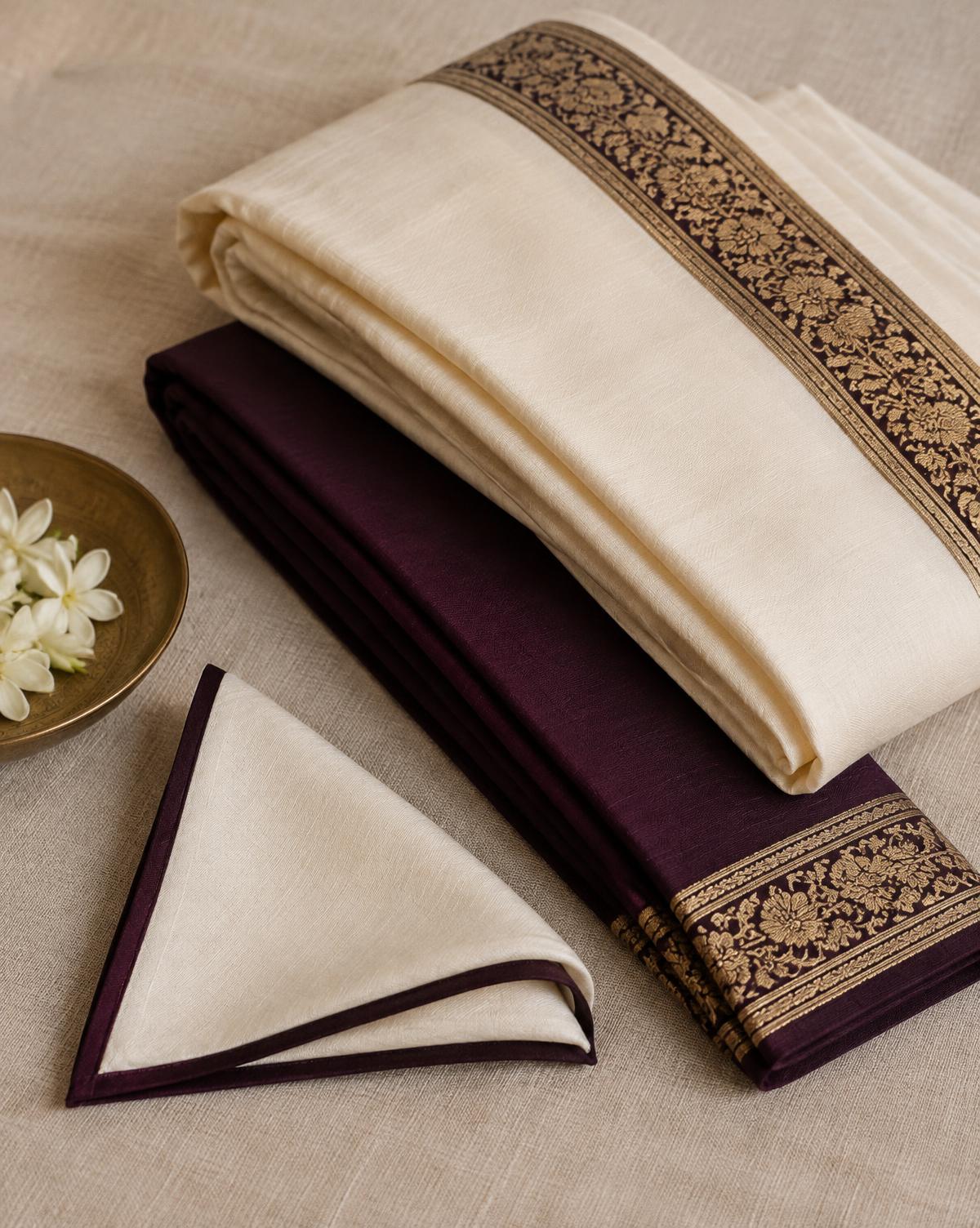 Folded ivory and plum pagh cloth with a bordered rumaal